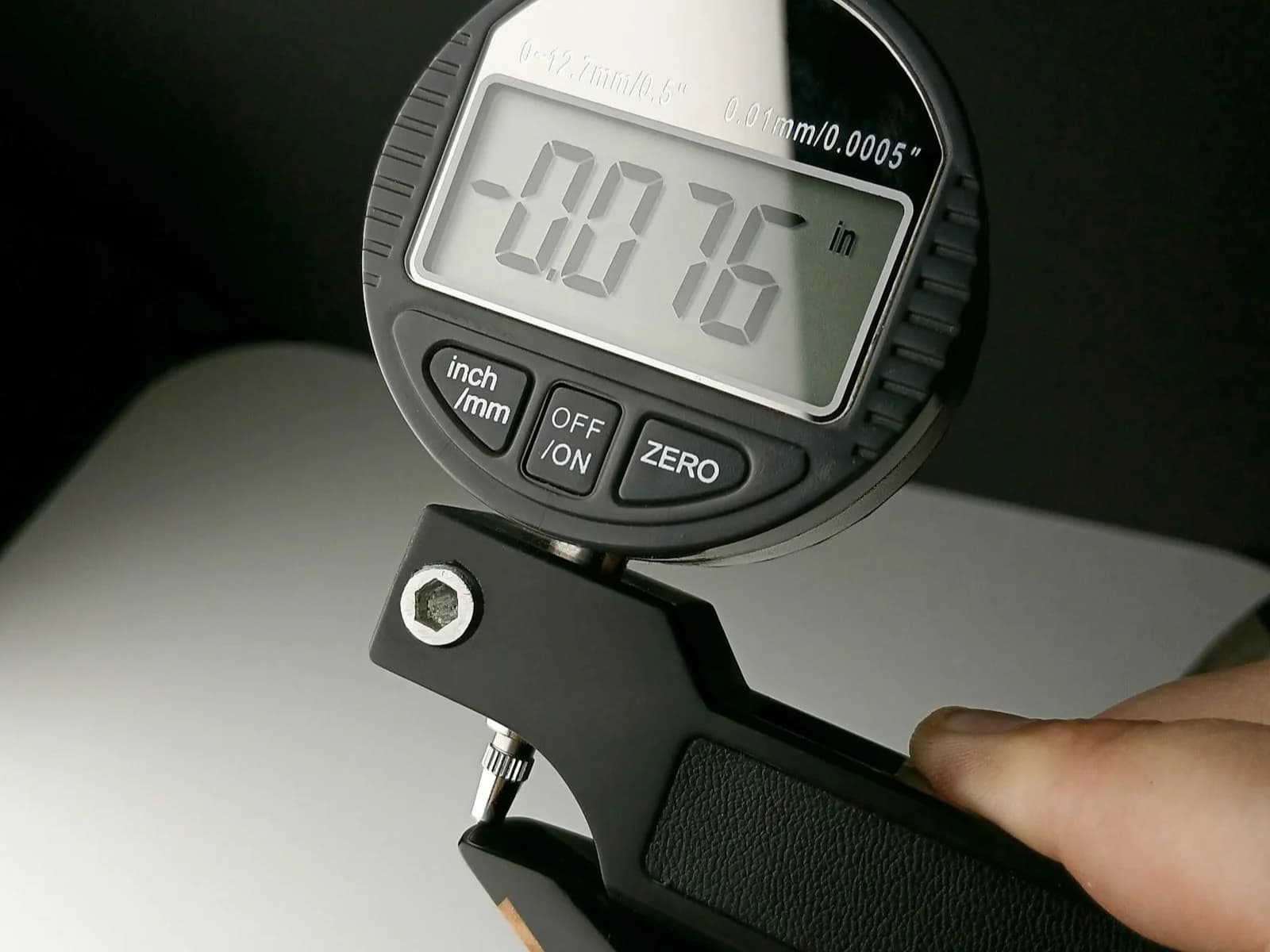Digital dial indicator showing a deviation of 0.076 inches during a part inspection