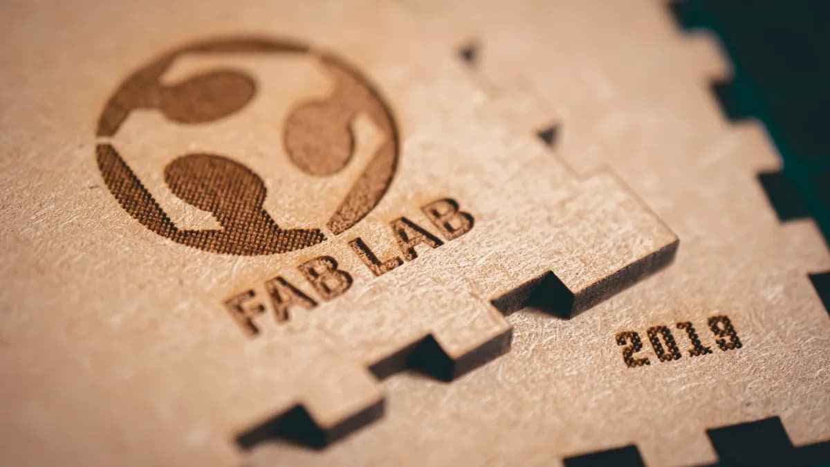 Wooden pieces with a logo and lettering burned into them by a laser, the result of engraving a vector file converted from a logo